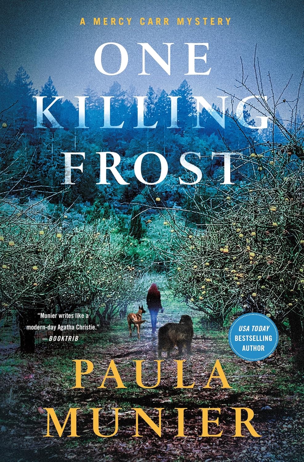 one-killing-frost-paula-munier 'One Killing Frost' book cover shows a woman walking with two dogs down a misty path between rows of bare apple trees, with a dark forest behind them.